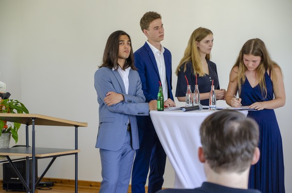 Schülerinnen und Schüler stehen an einem Stehtisch