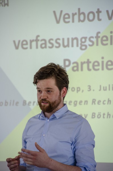 Sprecher steht vor einer Projektion einer Präsentation