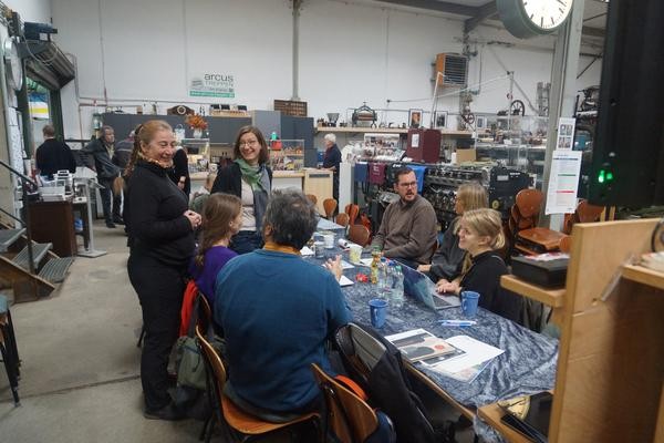 Mehrere Personen sitzen an einem Tisch in den Räumen des 3-Städte-Depots