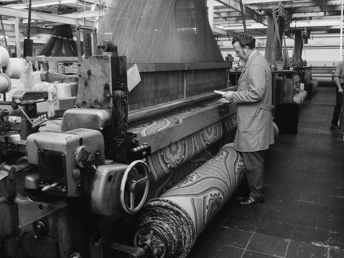 Schwarzweiß-Fotografie eines Mannes an einem Webstuhl