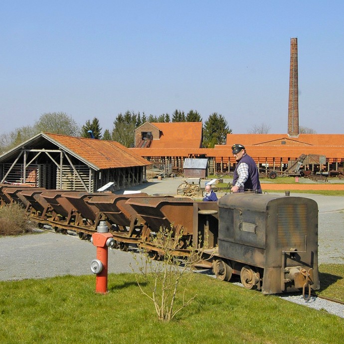 Feldbahn mit Loren vor der Kulisse der Ziegelei (vergrößerte Bildansicht wird geöffnet)